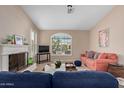 Cozy living room featuring a fireplace, large windows, and comfortable seating, perfect for Gathering gatherings at 16151 W Fairmount Ave, Goodyear, AZ 85395