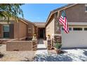 Inviting home exterior with a neutral color palette, stone accents, and desert landscaping at 16511 W Cortez St, Surprise, AZ 85388