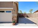 An outdoor space featuring garage access with stone accents and a privacy gate at 16511 W Cortez St, Surprise, AZ 85388