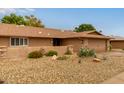 Single-story home with a desert rock yard and covered porch and a 2 car garage at 18211 N Conestoga Dr, Sun City, AZ 85373