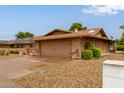 Single-story home featuring a desert rock yard, covered porch, and a two-car garage at 18211 N Conestoga Dr, Sun City, AZ 85373