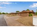 Neighborhood street view of desert landscaped homes featuring two car garages and covered porches at 18211 N Conestoga Dr, Sun City, AZ 85373