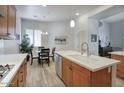 Open kitchen with wooden cabinets, stainless steel appliances, and dining area with bright light at 19475 N Grayhawk Dr # 1046, Scottsdale, AZ 85255