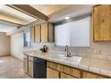 Bright kitchen with a double sink, tile countertops, and wooden cabinets at 3339 W Mohawk Ln, Phoenix, AZ 85027