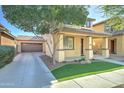 Inviting two-story home with a covered porch, synthetic lawn, and long driveway leading to a detached garage at 3455 E Oakland St, Gilbert, AZ 85295