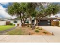 Attractive home with a modern garage door, mature trees, and meticulously maintained landscaping enhancing curb appeal at 3619 N 87Th St, Scottsdale, AZ 85251