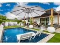 Luxurious pool and patio area featuring modern lounge chairs, outdoor seating beneath a shaded pergola, and lush landscaping at 3619 N 87Th St, Scottsdale, AZ 85251