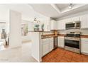 Well-lit kitchen with stainless steel appliances, light cabinets and terracotta tile floors at 3830 E Lakewood Pkwy # 2162, Phoenix, AZ 85048