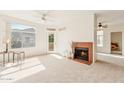 Bright living room featuring large windows, a ceiling fan, and a cozy fireplace at 3830 E Lakewood Pkwy # 2162, Phoenix, AZ 85048