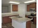 Well-lit kitchen with granite countertops, wood cabinets, and stainless steel appliances at 41246 N Vine Ave, San Tan Valley, AZ 85140
