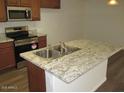 Kitchen island with a stainless steel sink, granite countertop, and stainless steel appliances at 41246 N Vine Ave, San Tan Valley, AZ 85140