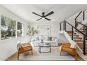 Bright living room showcasing a sofa, accent chairs, and a staircase with metal railings at 4323 N Miller Rd, Scottsdale, AZ 85251