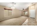 Spacious living room with carpet and tile flooring, neutral walls, and ample natural light at 4433 W Phalen Dr, Phoenix, AZ 85087