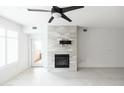 Bright living room featuring a modern ceiling fan, fireplace and seamless access to the outdoor patio at 4803 N Woodmere Fairway -- # 1003, Scottsdale, AZ 85251