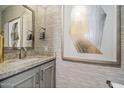 Chic powder room featuring a granite countertop vanity, designer wallpaper, and modern fixtures at 5250 E Deer Valley Dr # 206, Phoenix, AZ 85054