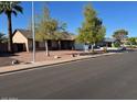 A lovely home with desert landscaping, mature trees, and a well-manicured lawn at 637 E Kramer St, Mesa, AZ 85203