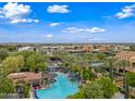 Expansive community pool area with lounge chairs, palm trees, and lush landscaping at 77 E Atole Ct, Queen Creek, AZ 85140