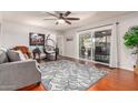 Cozy living room features hardwood floors, a ceiling fan, and a sliding glass door to the backyard at 810 W Villa Maria Dr, Phoenix, AZ 85023