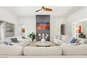 Bright living room with fireplace, ceiling fan, and white sofas in a modern home at 10778 N 137Th St, Scottsdale, AZ 85259