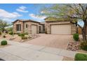 Elegant home with a paver driveway leading to a two-car garage and a well-manicured desert landscape at 1608 W Calle De Pompas --, Phoenix, AZ 85085
