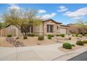 Charming home featuring a stone facade, desert landscaping, and mature trees in a well-maintained front yard at 1608 W Calle De Pompas --, Phoenix, AZ 85085