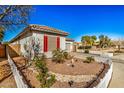 Well-maintained house with desert landscaping, red window shutters, and a white picket fence at 17704 W Tasha Dr, Surprise, AZ 85388
