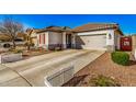 Single-Gathering home featuring a two-car garage, desert landscaping, and a charming white picket fence at 17704 W Tasha Dr, Surprise, AZ 85388