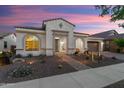 Twilight front view featuring desert landscape, tile roof, and welcoming entrance on a single-story home at 20977 W Mariposa St, Buckeye, AZ 85396