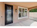 Covered entryway featuring a wrought-iron front door, decorative window, and stucco walls at 2270 E Honeysuckle Pl, Chandler, AZ 85249