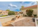 Cozy outdoor patio area featuring stone flooring and views of the landscaped neighborhood at 26473 W Runion Ln, Buckeye, AZ 85396