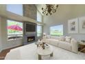 Bright living room features a fireplace, large windows, neutral tones, and elegant chandelier at 4020 E Laurel Ln, Phoenix, AZ 85028