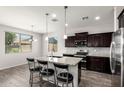 Modern kitchen with granite counters, stainless steel appliances, dark cabinetry, and an island with seating at 4253 E Palo Verde St, Gilbert, AZ 85296