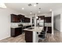 Contemporary kitchen boasting granite countertops, stainless steel appliances, dark cabinets, and an eat-in island at 4253 E Palo Verde St, Gilbert, AZ 85296