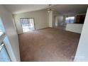 Open-concept living room with carpet flooring and sliding glass doors at 46037 W Starlight Dr, Maricopa, AZ 85139