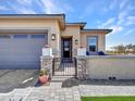 Inviting front entrance with stone pillars, pavers, wrought iron gate, and covered porch at 5581 N 206Th Ave, Buckeye, AZ 85396