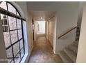 Inviting entryway with tiled floor and staircase leading to upper level and large front window at 6945 E Cochise Rd # 108, Paradise Valley, AZ 85253