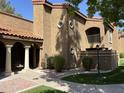 Well-manicured condo exterior with tiled roof, stucco walls, and landscaped yard at 6945 E Cochise Rd # 108, Paradise Valley, AZ 85253