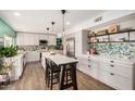 Modern kitchen featuring white cabinets, quartz countertops, backsplash, and an island with seating at 863 W Kiva Ave, Mesa, AZ 85210