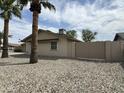 View of the backyard with desert landscaping, tall palm trees, and a block wall at 8637 E Weldon Ave, Scottsdale, AZ 85251