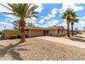 Charming single-story home showcasing desert landscaping and inviting curb appeal with mature palm trees at 8637 E Weldon Ave, Scottsdale, AZ 85251