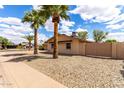 A one-story home with desert landscaping featuring well-maintained gravel and mature palm trees at 8637 E Weldon Ave, Scottsdale, AZ 85251