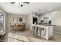 Eat-in kitchen features white cabinets, stainless appliances, a breakfast bar, and a dining area at 8637 E Weldon Ave, Scottsdale, AZ 85251