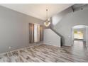 Open-concept living room with hardwood floors and elegant chandelier at 8708 S 50Th Ln, Laveen, AZ 85339