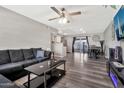 Open living room with wood floors, modern furnishings, and a view of the kitchen and dining area at 903 N Revere St # F, Mesa, AZ 85201
