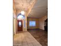 Open living room features a large arched window and dark wood-look floors at 11233 W Olive Dr, Avondale, AZ 85392