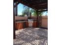 A covered outdoor kitchen area featuring a built in grill perfect for entertaining guests at 11233 W Olive Dr, Avondale, AZ 85392