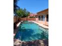 Sparkling private pool in backyard with a mature green landscape providing a relaxing outdoor oasis at 11233 W Olive Dr, Avondale, AZ 85392
