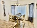 Cozy dining area with a square table, four chairs, stylish chandelier and bright natural light at 12371 W Hadley St, Avondale, AZ 85323