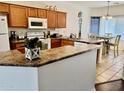 Well-equipped kitchen featuring wooden cabinets, modern appliances, and an adjacent dining area at 12371 W Hadley St, Avondale, AZ 85323