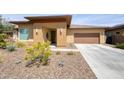 Inviting desert home featuring a two-car garage, covered front entrance, and low-maintenance landscaping at 13204 W Via Dona Rd, Peoria, AZ 85383